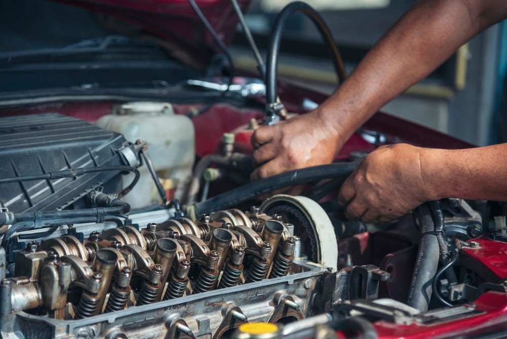 closeup of man's hands repairing an engine